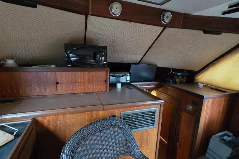 Slide: The Image of Interior of a 1975 Hatteras 46 Convertible yacht with wooden cabinetry and modern appliances. - 12