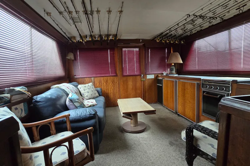 Slide: The Image of Interior of a 1975 Hatteras 46 Convertible yacht with cozy seating and fishing rods. - 15