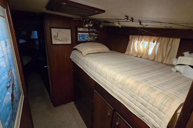 Slide: The Image of Cozy cabin interior of 1975 Hatteras 46 Convertible yacht with bed and wooden furnishings. - 21