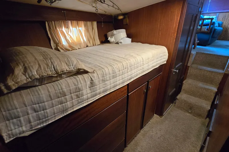 Slide: The Image of Cozy cabin interior of 1975 Hatteras 46 Convertible yacht with bed and wooden cabinetry. - 22