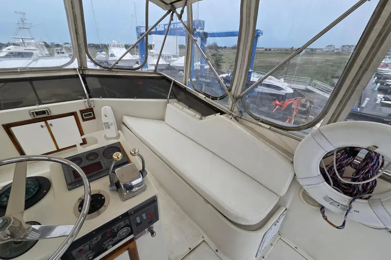 Slide: The Image of Cockpit of 1975 Hatteras 46 Convertible yacht with steering wheel and seating area. - 26