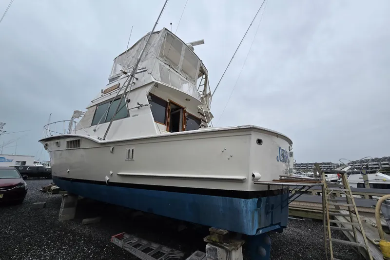 Slide: The Image of 1975 Hatteras 46 Convertible boat on dry dock, overcast sky background. - 3