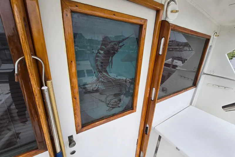 Slide: The Image of 1975 Hatteras 46 Convertible boat with wooden-framed glass doors and marlin design. - 34