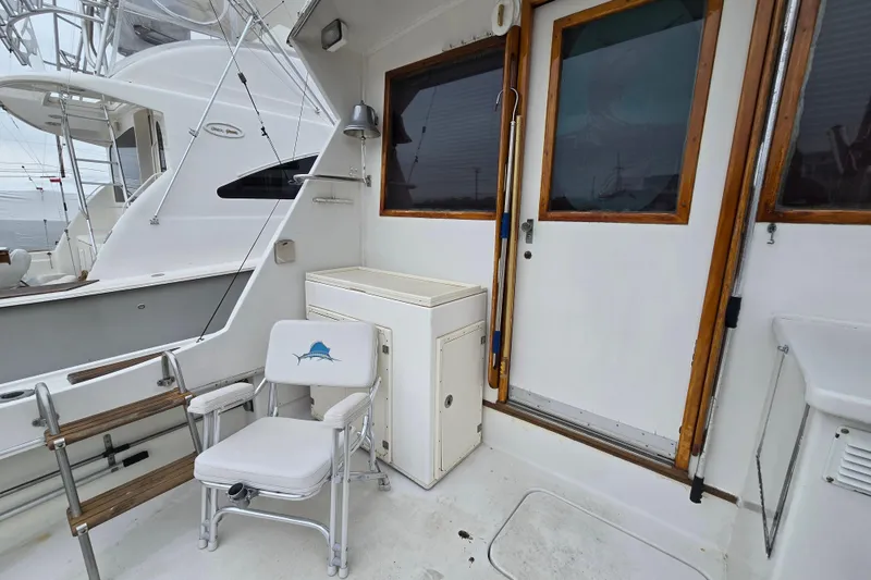 Slide: The Image of 1975 Hatteras 46 Convertible yacht deck with fishing chair and wooden accents. - 35