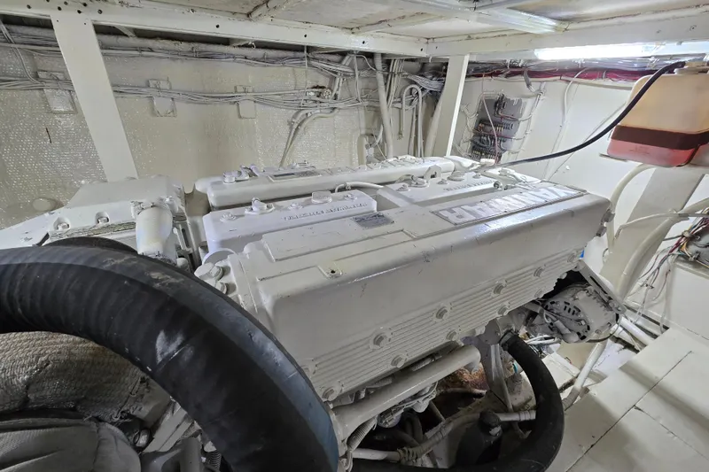 Slide: The Image of Engine room of a 1975 Hatteras 46 Convertible yacht, showcasing a white marine engine. - 38