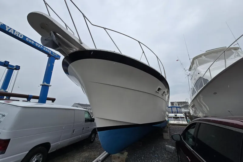 Slide: The Image of 1975 Hatteras 46 Convertible boat on dry dock, surrounded by vehicles. - 5