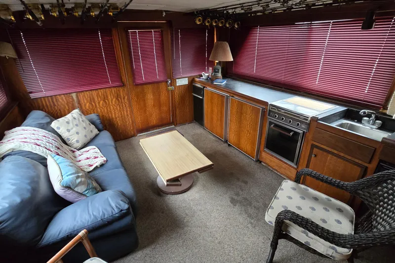 Slide: The Image of Interior of a 1975 Hatteras 46 Convertible yacht with cozy seating and kitchen area. - 9