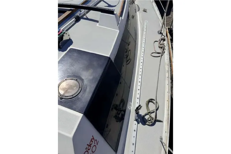 Slide: The Image of 1988 O'Day 302 sailboat deck with ropes and hatch, showcasing sleek design. - 11
