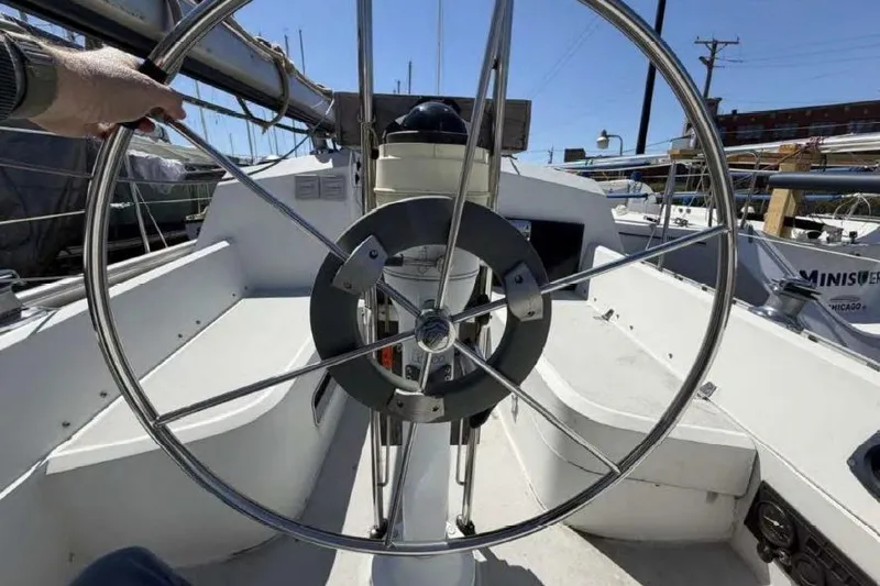 Slide: The Image of 1988 O'Day 302 sailboat cockpit with steering wheel and navigation instruments. - 13