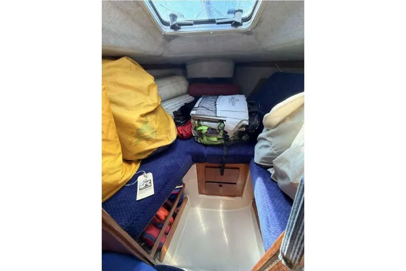 Slide: The Image of Interior cabin of a 1988 O'Day 302 sailboat with storage and cushions. - 26