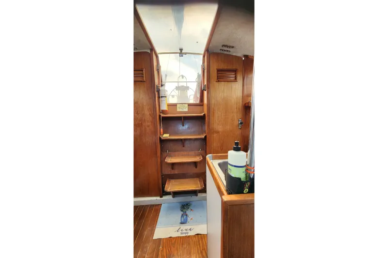 Slide: The Image of Interior of a 1988 O'Day 302 sailboat with wooden steps and nautical decor. - 31