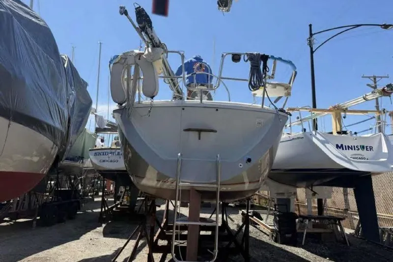 Slide: The Image of 1988 O'Day 302 sailboat on dry dock, surrounded by other boats, under clear blue sky. - 4