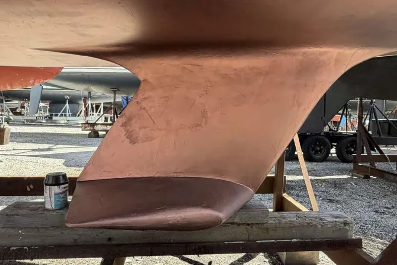 Slide: The Image of 1988 O'Day 302 sailboat keel with fresh copper paint in a boatyard setting. - 7