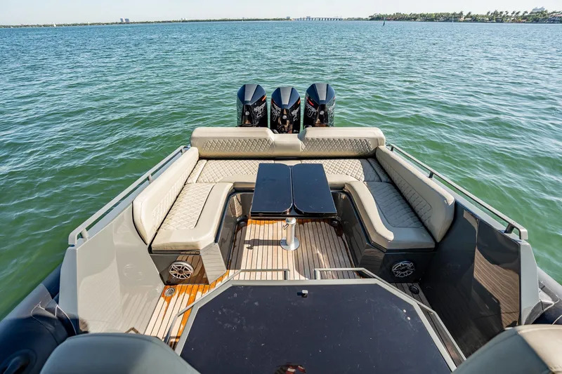 Slide: The Image of Luxurious 2023 Skipper-BSK 38NC boat with triple engines and elegant seating on open water. - 104