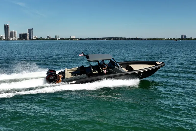 Slide: The Image of 2023 Skipper-BSK 38NC boat cruising on a sunny day near a city skyline. - 12