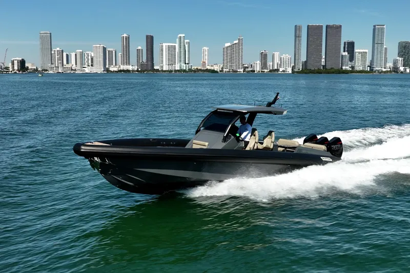 Slide: The Image of 2023 Skipper-BSK 38NC boat cruising on water with city skyline backdrop. - 13