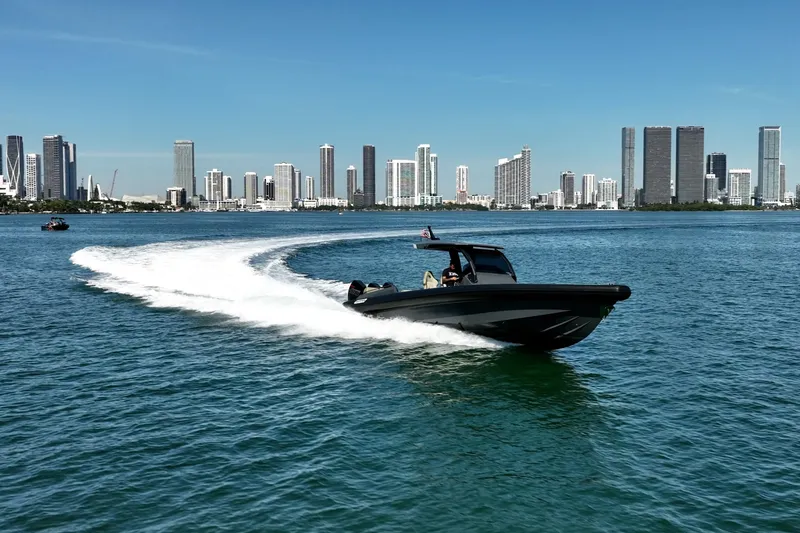 Slide: The Image of 2023 Skipper-BSK 38NC boat cruising near city skyline on sunny day. - 14