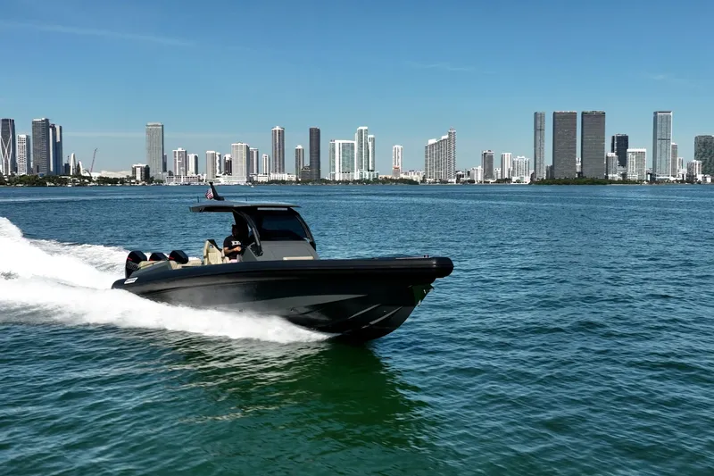 Slide: The Image of 2023 Skipper-BSK 38NC boat cruising on water with city skyline backdrop. - 15