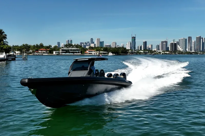 Slide: The Image of 2023 Skipper-BSK 38NC speedboat cruising near city skyline on sunny day. - 17