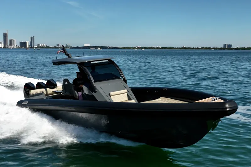 Slide: The Image of 2023 Skipper-BSK 38NC boat cruising on a sunny day near a city skyline. - 18