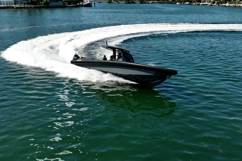Slide: The Image of 2023 Skipper-BSK 38NC speedboat making a sharp turn on clear blue water. - 21