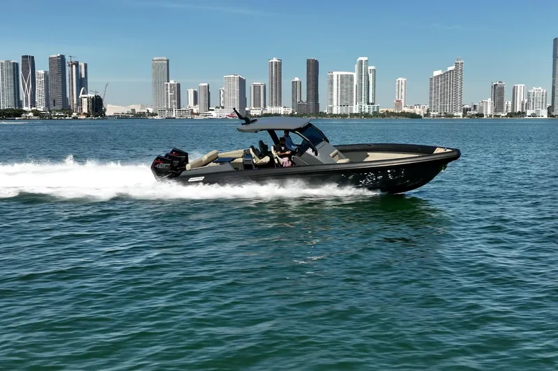 Slide: The Image of Skipper-BSK 38NC boat cruising near city skyline, 2023 model. - 3