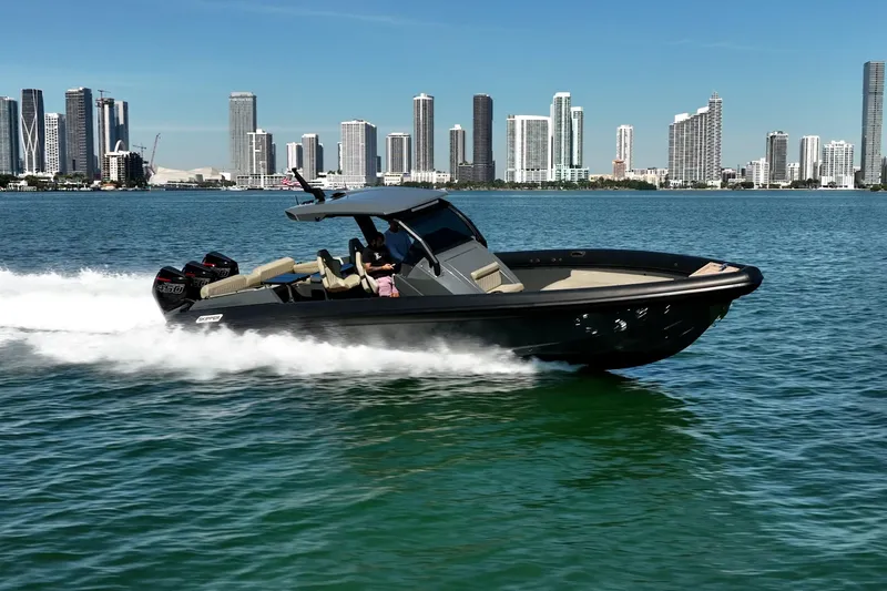 Slide: The Image of 2023 Skipper-BSK 38NC boat cruising on water with city skyline in background. - 4