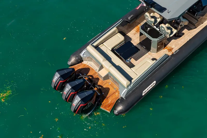 Slide: The Image of 2023 Skipper-BSK 38NC boat with triple outboard engines on turquoise water. - 41