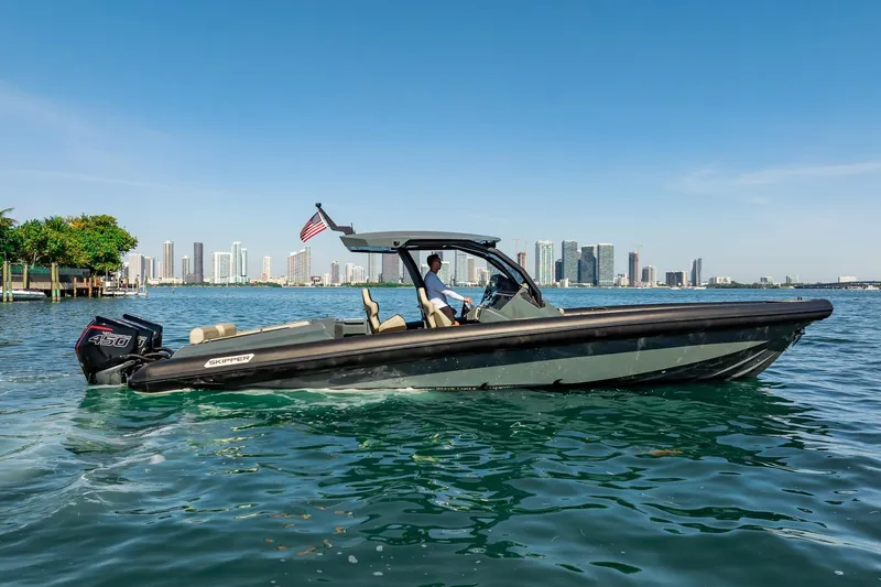 Slide: The Image of 2023 Skipper-BSK 38NC boat cruising on water with city skyline in background. - 43
