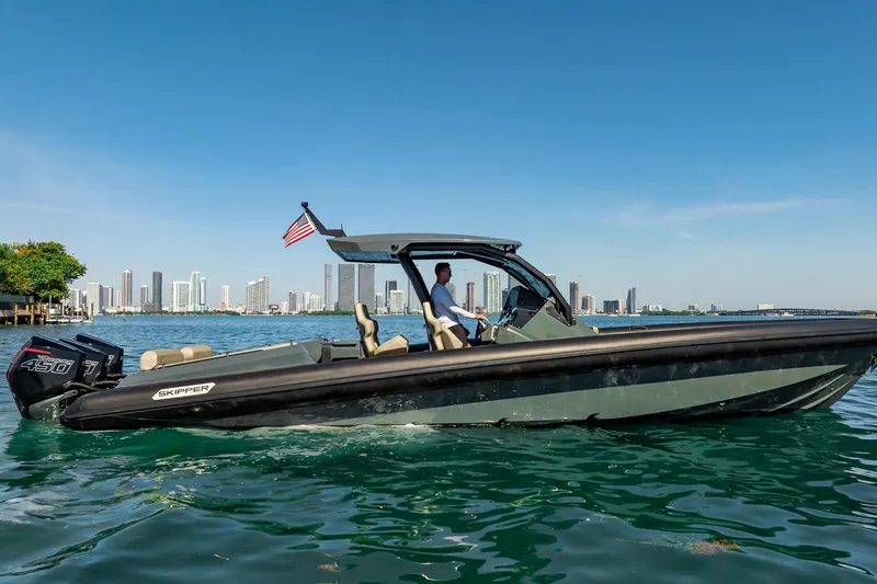Slide: The Image of 2023 Skipper-BSK 38NC boat cruising near city skyline on a sunny day. - 44