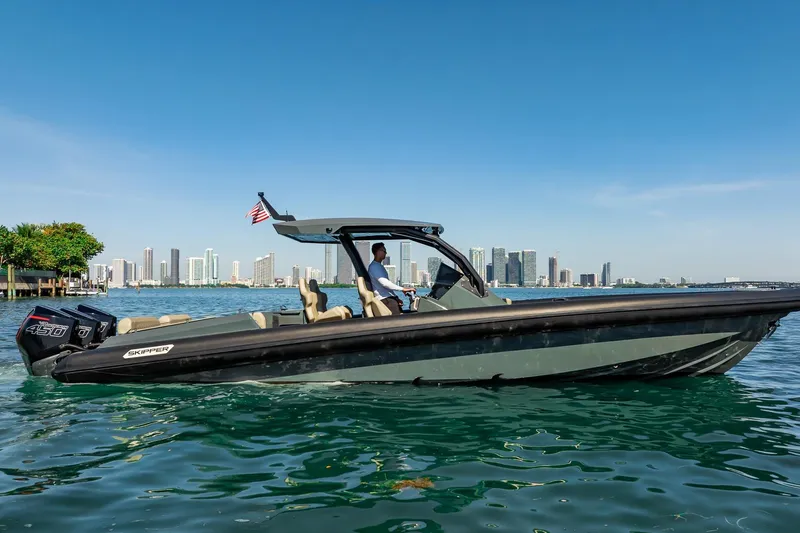 Slide: The Image of 2023 Skipper-BSK 38NC boat cruising near city skyline on a sunny day. - 45