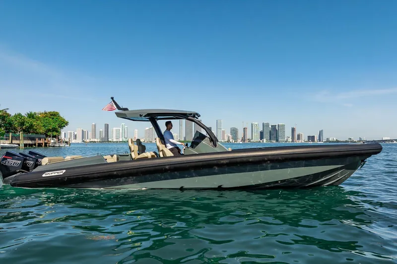 Slide: The Image of 2023 Skipper-BSK 38NC boat cruising near city skyline on a sunny day. - 46