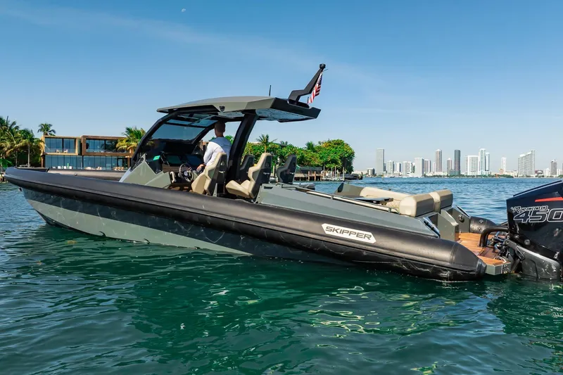 Slide: The Image of 2023 Skipper-BSK 38NC boat cruising near a city skyline on a sunny day. - 56