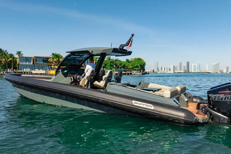 Slide: The Image of 2023 Skipper-BSK 38NC boat cruising on a sunny day near a city skyline. - 57