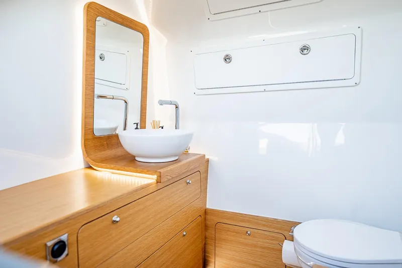 Slide: The Image of Modern yacht bathroom with wooden cabinetry, vessel sink, and mirror on Skipper-BSK 38NC, 2023 model. - 60
