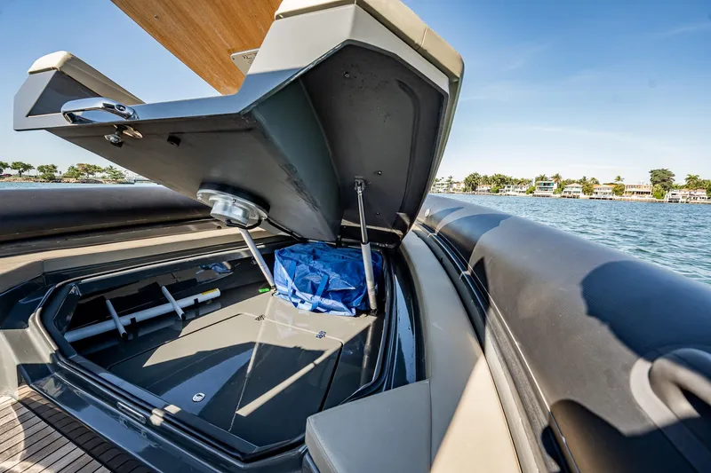 Slide: The Image of Open storage compartment on 2023 Skipper-BSK 38NC boat, with blue bag and scenic waterfront view. - 65