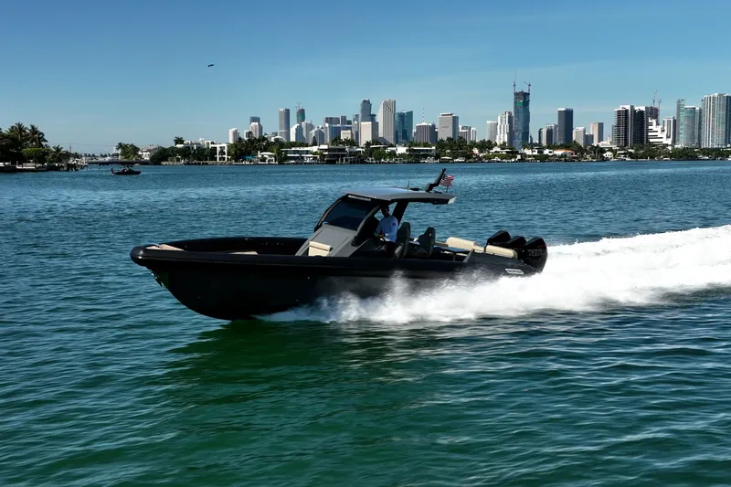Slide: The Image of 2023 Skipper-BSK 38NC boat cruising on water with city skyline in background. - 7