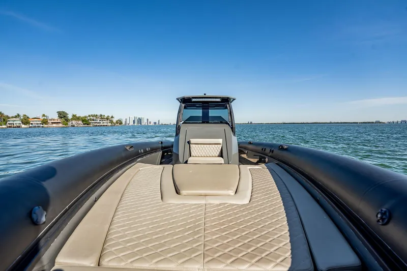 Slide: The Image of 2023 Skipper-BSK 38NC boat on water, luxury seating, city skyline in background. - 76