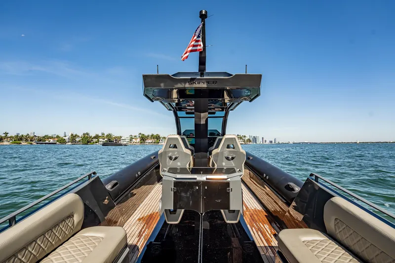 Slide: The Image of Luxury Skipper-BSK 38NC boat on water, 2023 model, with city skyline in background. - 85