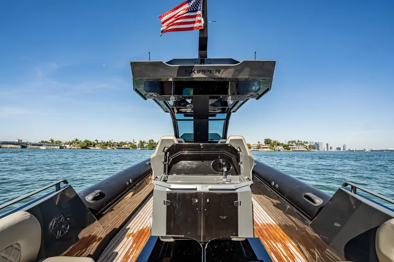 Slide: The Image of 2023 Skipper-BSK 38NC boat with American flag, cruising on a sunny day. - 92