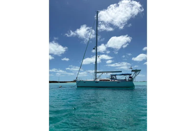 Slide: The Image of Sailing yacht Beneteau Oceanis 46, 2010 model, anchored in clear turquoise waters under a blue sky. - 21