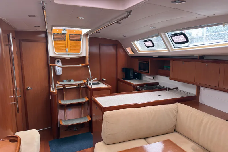 Slide: The Image of Interior of 2010 Beneteau Oceanis 46 yacht, featuring a cozy kitchen and seating area. - 22
