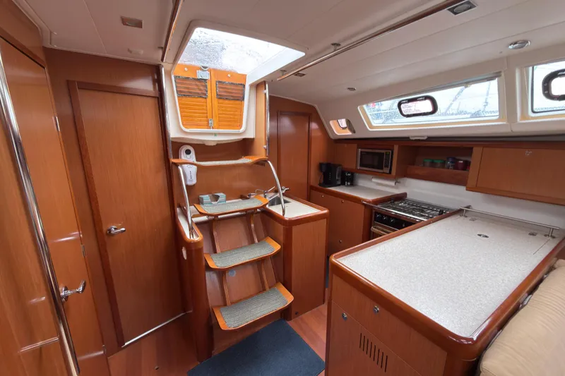 Slide: The Image of Interior of 2010 Beneteau Oceanis 46 yacht with wooden cabinetry and modern kitchen amenities. - 23