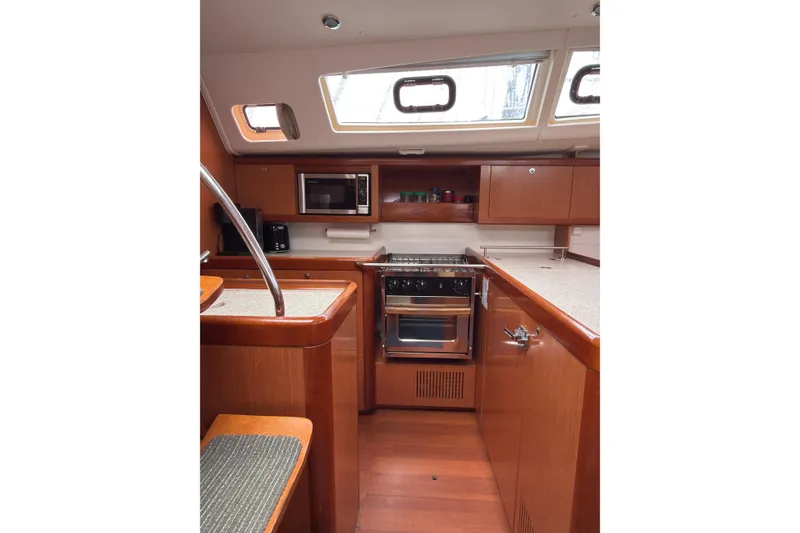 Slide: The Image of Interior of 2010 Beneteau Oceanis 46 yacht kitchen with wood cabinetry and modern appliances. - 25