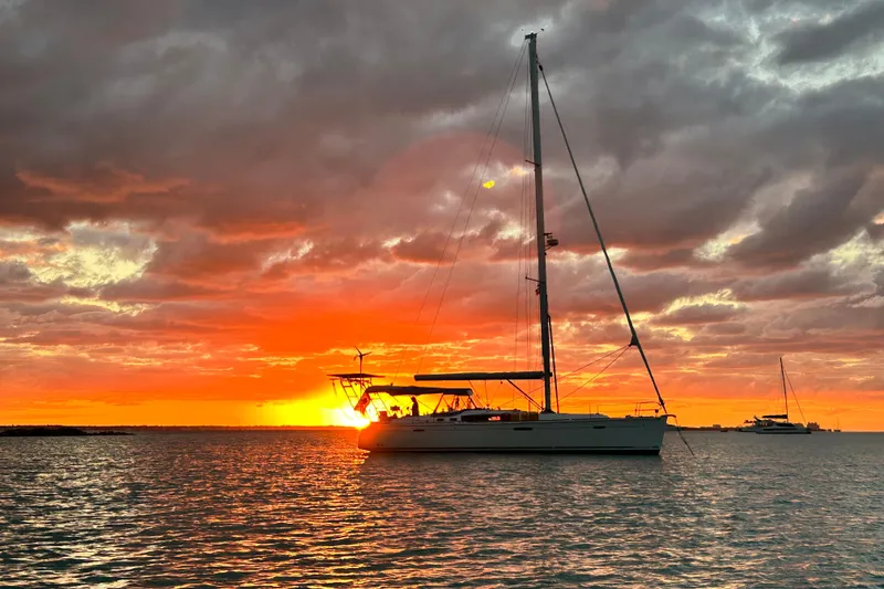 Slide: The Image of Beneteau Oceanis 46 sailboat at sunset, 2010 model, silhouetted against vibrant sky. - 3