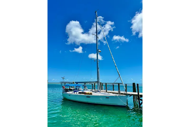 Slide: The Image of Beneteau Oceanis 46 sailboat docked in clear turquoise water, under a bright blue sky. - 4