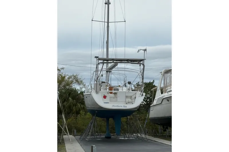 Slide: The Image of 2010 Beneteau Oceanis 46 sailboat on stands, outdoor storage, overcast sky. - 45