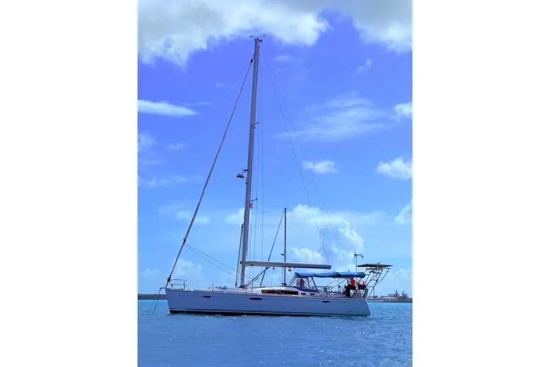 Slide: The Image of 2010 Beneteau Oceanis 46 sailboat on calm blue waters under a clear sky. - 46