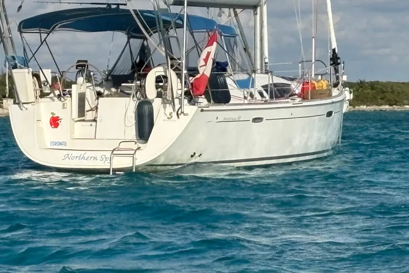 Slide: The Image of Beneteau Oceanis 46 sailboat from 2010 on blue water, featuring a Canadian flag. - 8