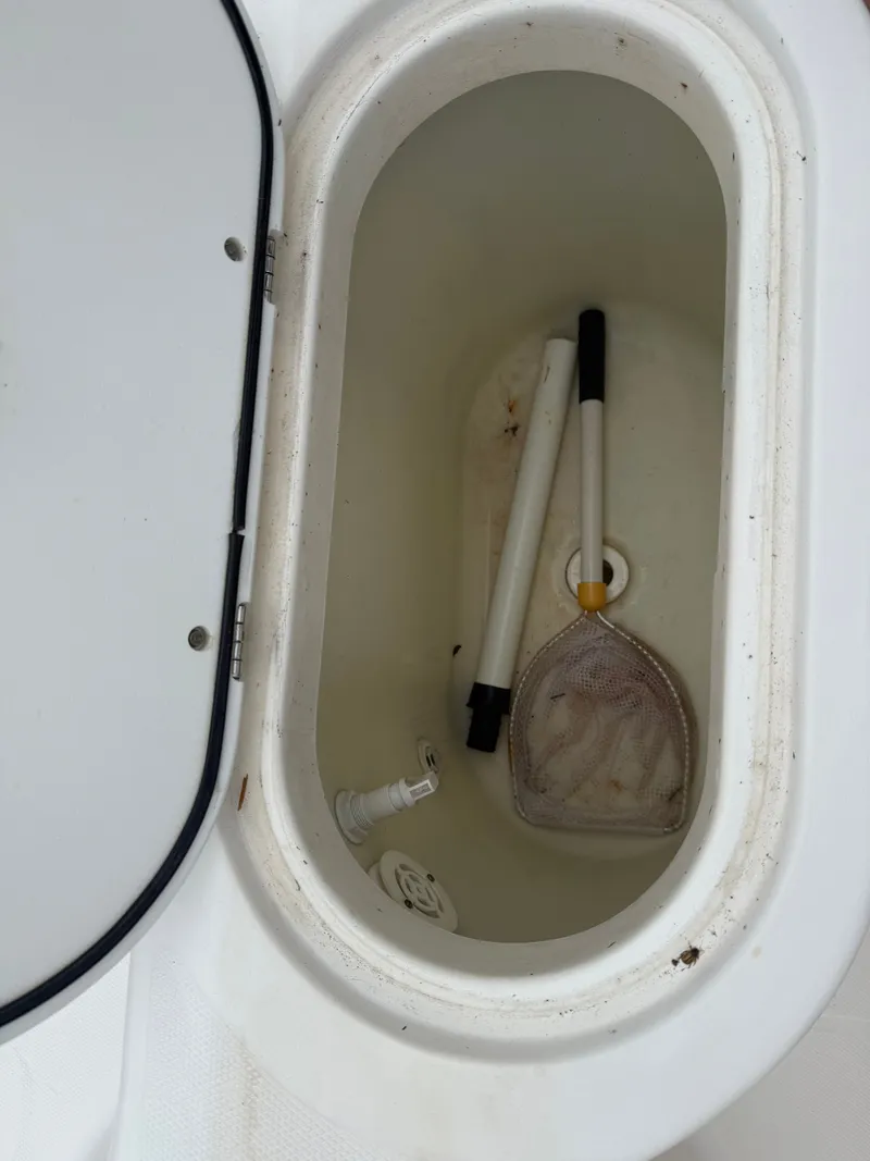 Slide: The Image of Wellcraft 212 Fisherman 2005 storage compartment with fishing gear. - 8